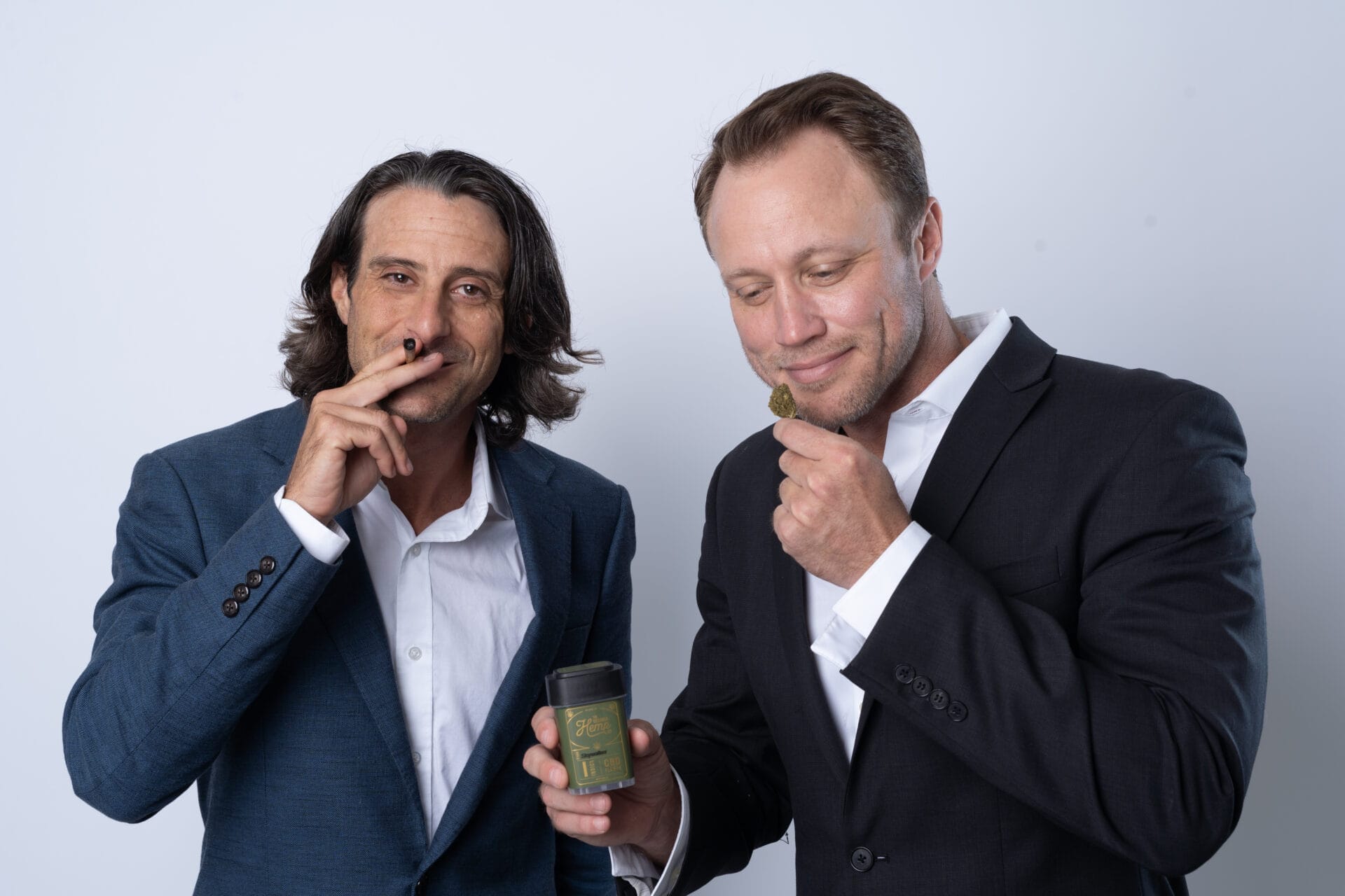 The Georgia Hemp Company Founders Joe Salome and Ryan Dills standing side by side with a jar of hemp and a lit joint